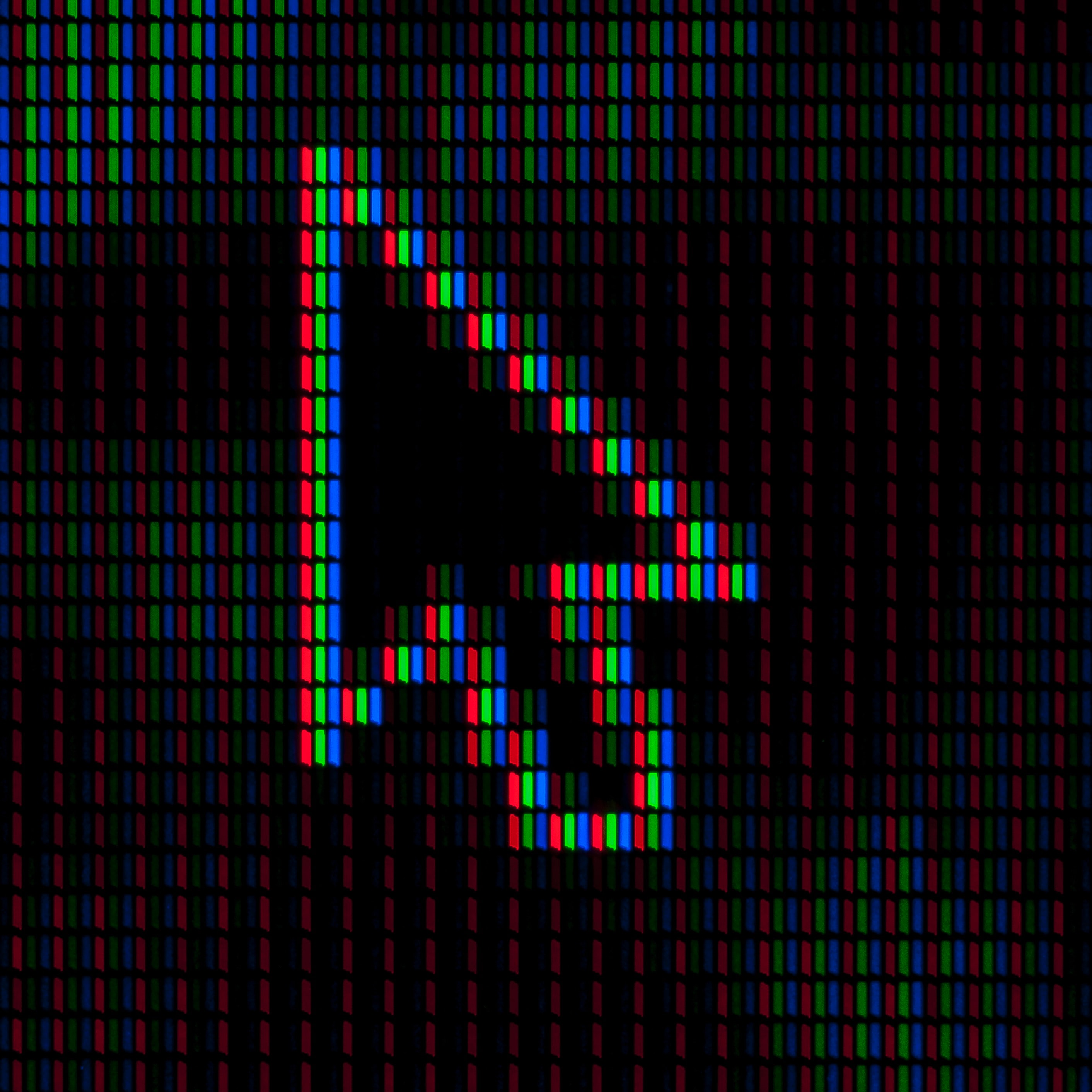 Image représente le curseur d'une souris d'ordinateur sur des néons rouges, verts et bleus